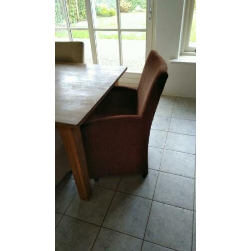 2 goedzittende bruine (eetkamer)fautuils op wieltjes.