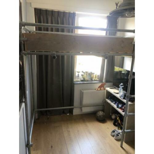 Stoere steigerhouten hoogslaper met steigerbuizen onderstel.