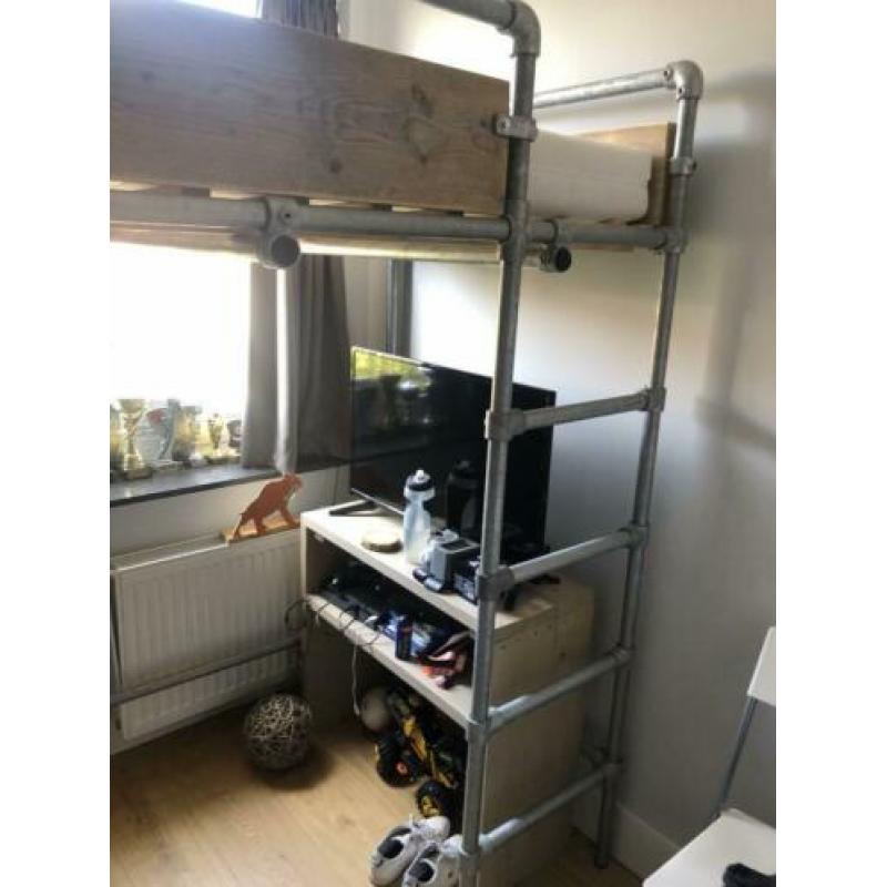 Stoere steigerhouten hoogslaper met steigerbuizen onderstel.